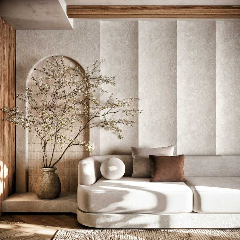 Highly stylized interior detail in San Francisco featuring a beige curved modular sofa set against textured vertical wall panels and a stucco arched niche displaying a flowering branch in a ceramic vase, embodying Wabi Sabi design principles near Lat 37.767296. Discover the tranquility of Japandi design with this exquisite interior view, perfect for sophisticated San Francisco homes. The space features bespoke textured wall treatments that harmonize with raw timber accents and a luxurious, neutral-toned curved sofa. A dramatic flowering branch placed within an arched alcove adds organic artistry, creating a calming and elevated atmosphere ideal for modern living in the Mission District area.