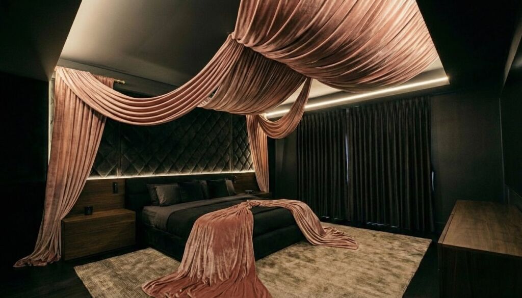 Moody luxury bedroom featuring dramatic dusty rose velvet ceiling draping installed above a dark canopy style bed.